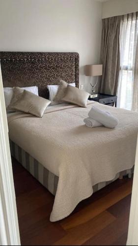 une chambre avec un grand lit avec des draps et des oreillers blancs dans l'établissement Charmant 2 pcs + Parking + Balcon + 1 min plages, à Cannes