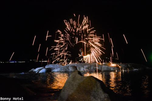 a firework display at night with a palm tree at Bonny Hotel 4 Floors No Elevator in Lamai