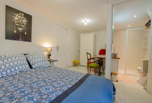 1 dormitorio con 1 cama azul, mesa y sillas en Chaource, en Chaource
