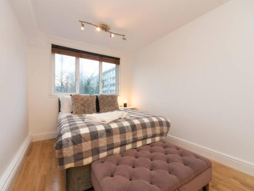 a bedroom with a bed and a window at Pass the Keys Canal-view flat near Madame Tussauds in London