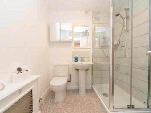 a white bathroom with a toilet and a shower at Pass the Keys Canal-view flat near Madame Tussauds in London