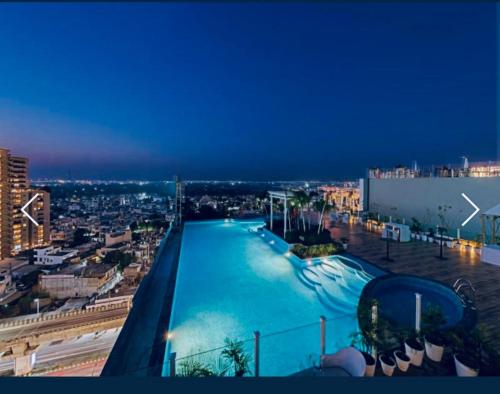 a view of a large swimming pool at night at The Grand Anukampa Inn Pink City in Jaipur