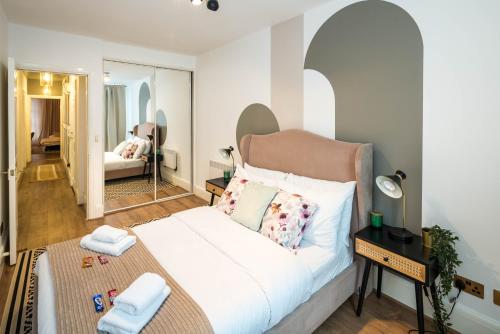 Schlafzimmer mit einem Bett und einem Spiegel in der Unterkunft Ventilated Central 2BR Flat 5 min from Station in London
