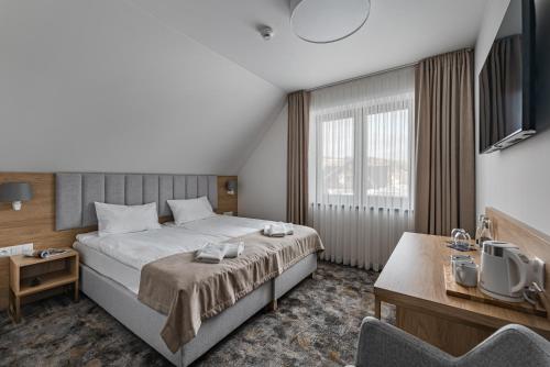 a hotel room with a bed and a tv at Złoty Kłos Łapsze Niżne in Łapsze Niżne
