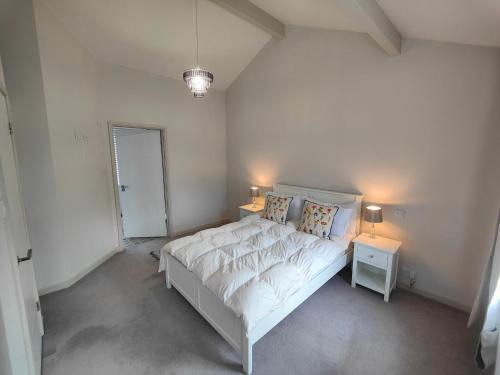 a bedroom with a white bed and two night stands at Chandlers Ford Home in Southampton