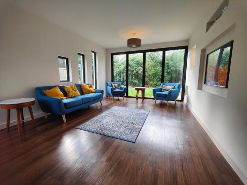 a living room with a blue couch and two chairs at Chandlers Ford Home in Southampton