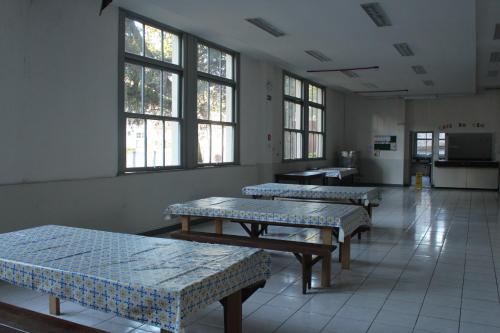 um quarto com quatro bancos num quarto com janelas em Casa do Estudante Universitário do Paraná em Curitiba