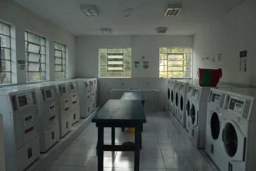 uma lavandaria com máquinas de lavar roupa e uma mesa em Casa do Estudante Universitário do Paraná em Curitiba