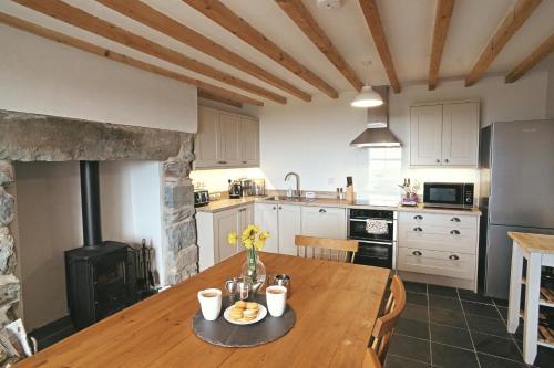 a kitchen with a wooden table in a room at Ty-Newydd, Frongaled in Dyffryn