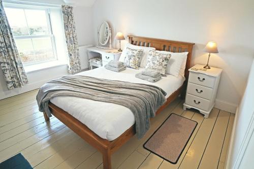 a bedroom with a bed and a mirror and a window at Ty-Newydd, Frongaled in Dyffryn