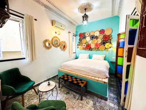 a bedroom with a bed with a painting on the wall at Riad Verus in Fès