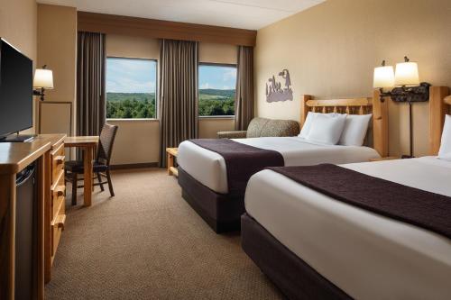 een hotelkamer met 2 bedden en een televisie bij Great Wolf Lodge New England in Leominster