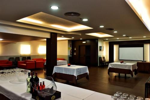 a restaurant with two tables and a projection screen at Hotel Alda Carril in Vilagarcia de Arousa
