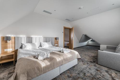 a bedroom with a large bed and a couch at Złoty Kłos Łapsze Niżne in Łapsze Niżne
