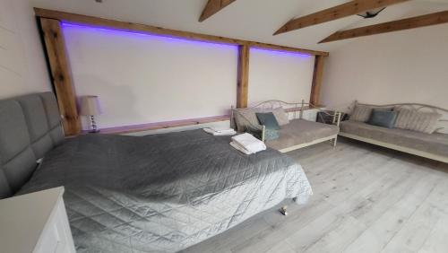 a bedroom with a large bed and a couch at Aparthotel Riva in Zawiercie