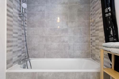 y baño con ducha y bañera blanca. en Magnifique appartement à proximité de Paris, en Saint-Ouen