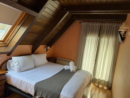 a bedroom with a large bed with a large window at Hotel Saueth in Tredós