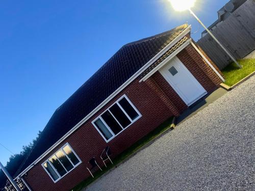 a red brick house with a white door at Beautiful 3-Bed Bungalow in Bawtry Doncaster in Doncaster