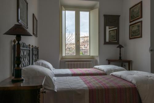 a bedroom with three beds and a window at Il Cardo in Spinetoli