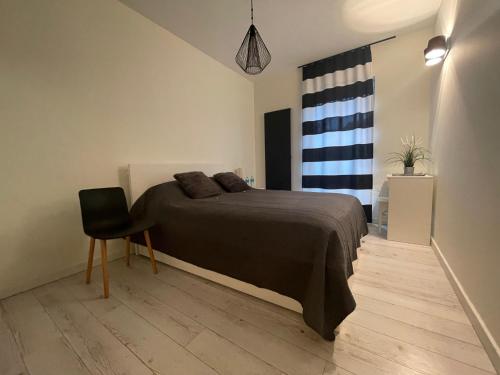 a bedroom with a bed and a chair and a window at Boznicza Modern Apartment, self check-in 24h, free parking in Poznań
