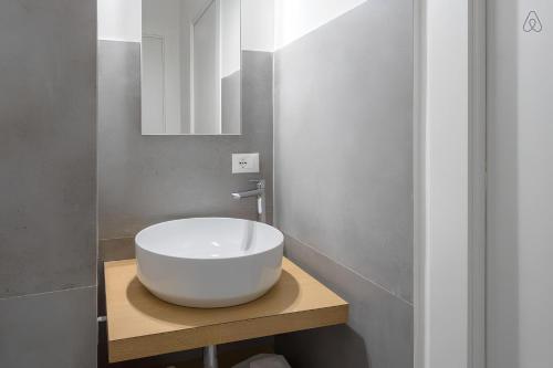 a bathroom with a white bowl sink on a wooden counter at FAMM Apartments - Charming open space in Trastevere in Rome
