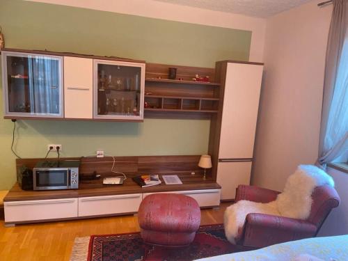 a living room with a desk with a microwave and chairs at Haus Karin Mallnitz in Mallnitz