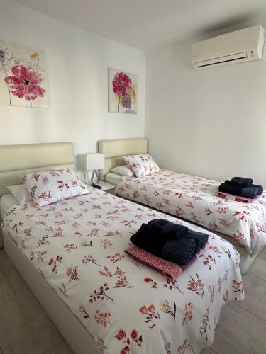 1 dormitorio con 2 camas con sábanas rojas y blancas en Los Gracioseros Apt 207, en Puerto del Carmen