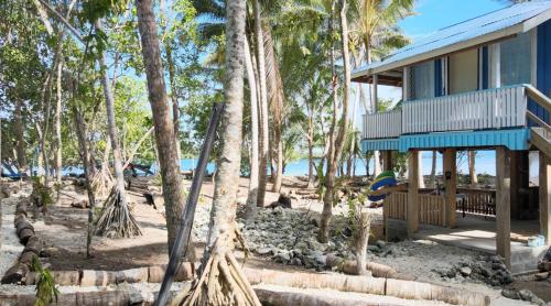 a house on the beach with palm trees at welcome to putuo ecolodge hidden germ of Solomon 