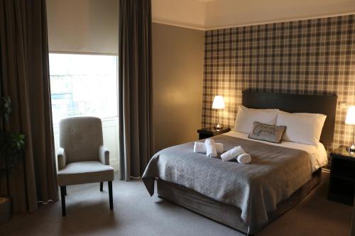 ein Hotelzimmer mit einem Bett und einem Stuhl in der Unterkunft Norfolk Arms in Glossop