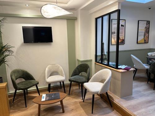 a waiting room with chairs and a tv on the wall at Hotel Little Regina in Paris
