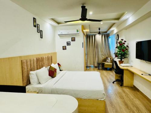The Grand Anukampa Inn Pink City في جايبور: غرفة نوم مع سرير ومكتب مع جهاز كمبيوتر