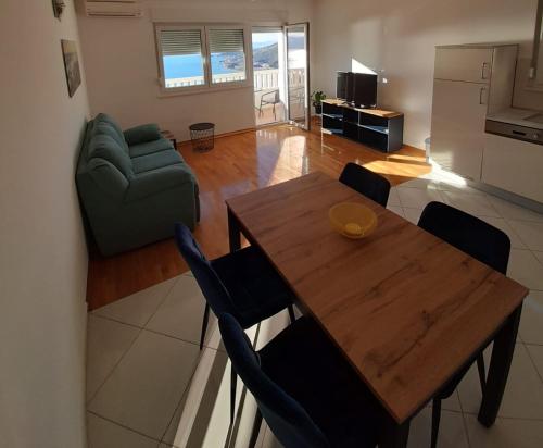 ein Wohnzimmer mit einem Holztisch und einem Sofa in der Unterkunft Pere Apartment in Omiš