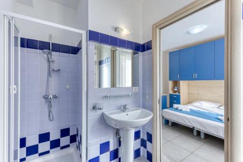 a bathroom with a sink and a shower and a bed at Camere con vista mare a 30 m dal mare in Torre San Giovanni Ugento