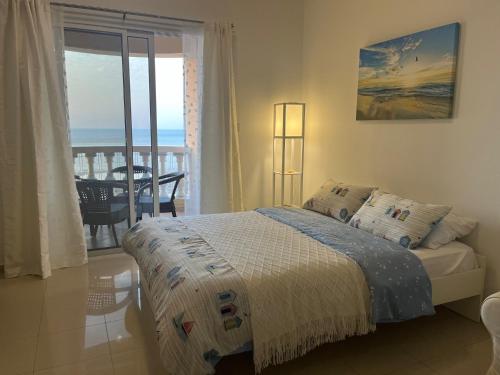 a bedroom with a bed with a view of the ocean at Ocean Breeze in Ras al Khaimah
