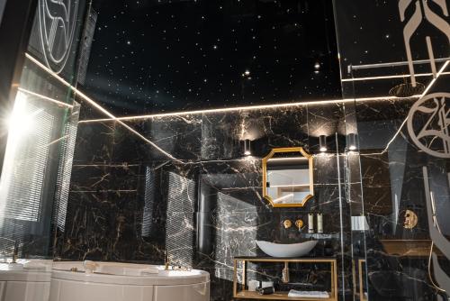 a bathroom with a black marble wall and a sink at Złoty Kłos Łapsze Niżne in Łapsze Niżne