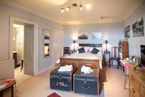 a bedroom with a bed with suitcases in it at Buckthorns House in Leven-Fife