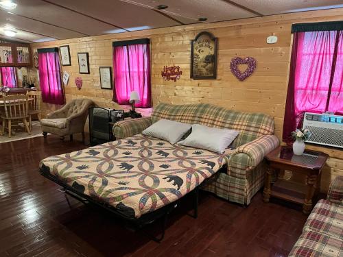 ein Wohnzimmer mit einem Bett und einem Sofa in der Unterkunft Twin Oaks in Bryson City
