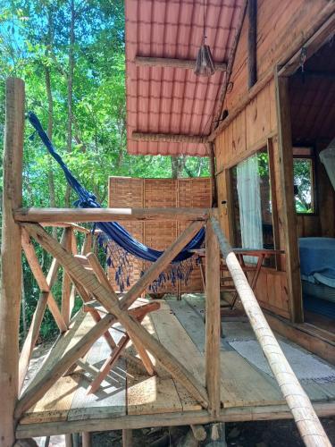 a log cabin with a hammock on the porch at RECANTO DO SENTIR, conexão com a natureza e muita paz. in Praia do Forte
