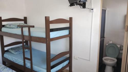 a room with two bunk beds and a toilet at Pousada Do Léo in Bertioga