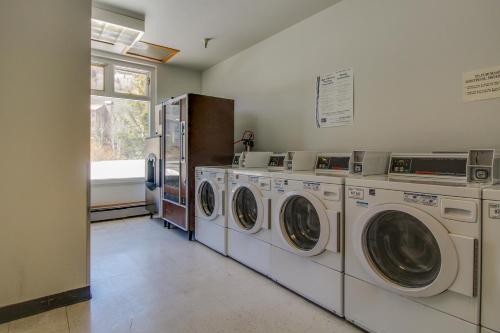 a laundry room with three washing machines and a window at Village Square in Copper Mountain