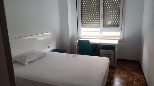 - une chambre avec un lit blanc et une fenêtre dans l'établissement Apartamento centro Vitoria, à Vitoria-Gasteiz