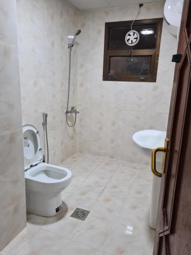 een badkamer met een toilet en een wastafel bij Cozy Corner 2024 in Abu Dhabi