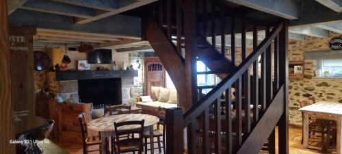 escalera de madera en una habitación con mesa y sillas en Le Refuge, en Genouillac