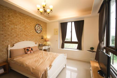 a bedroom with a white bed with a brick wall at 城市角落民宿 in Hualien City