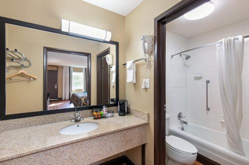 ein Badezimmer mit einem Waschbecken, einem WC und einem Spiegel in der Unterkunft Super 8 by Wyndham Kingsport in Kingsport