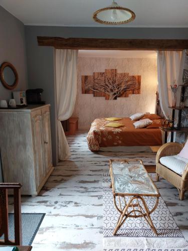 a bedroom with a bed and a table and a chair at Chambres d'Hôtes de l'Ile du Saule in Saumur