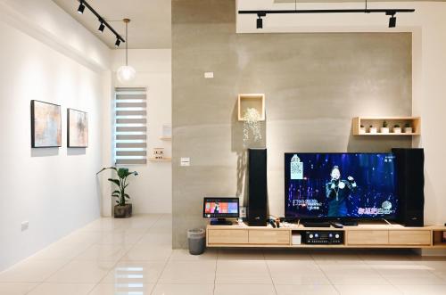ein Wohnzimmer mit einem großen Flachbild-TV in der Unterkunft Mo Guesthouse in Shangwu
