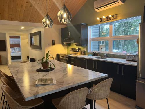 a kitchen with a large island with chairs in it at Chalet le Rassembleur in Racine