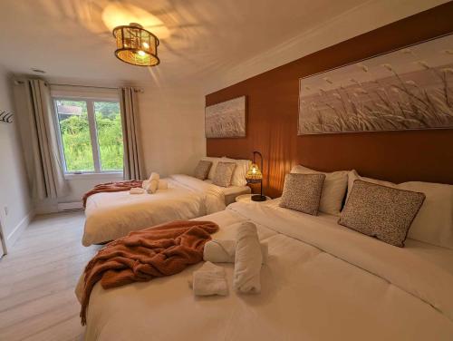 a bedroom with two beds and a large window at Chalet le Rassembleur in Racine