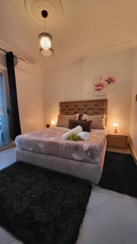 タンジェにあるAppart Hôtel Tanger Panameのラグ付きの客室で、ベッドルーム1室(大型ベッド1台付)